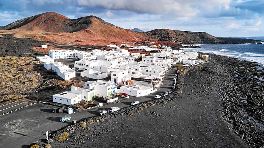 Vue aérienne du village d'El Golfo entre volcans et côte de lave noire